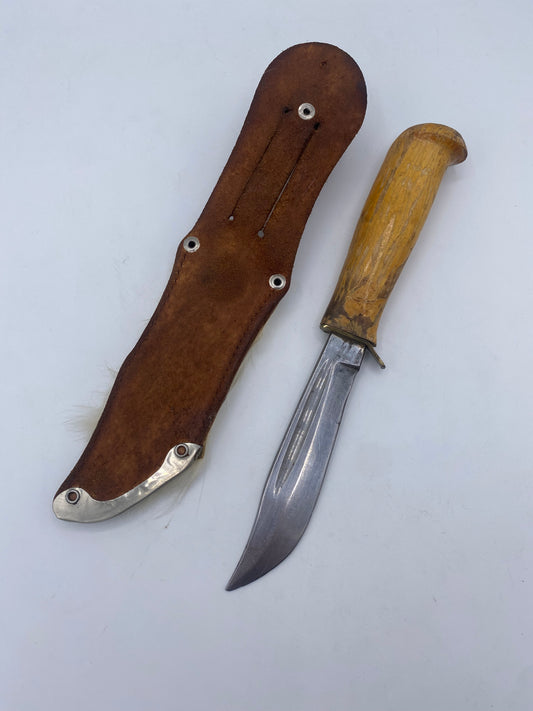En ældre kniv i puukko-stil med skede og en gammel skæde. Skandinavien. 20. Årh