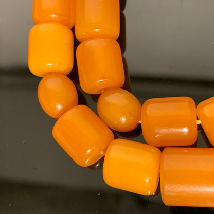 "Vintage bead necklace made of yellow glass beads. The beads are shaped like small squares and are strung together on a gold chain