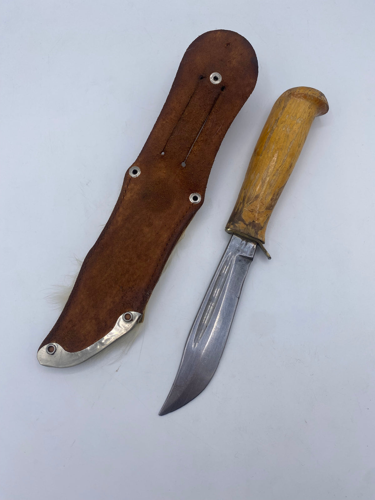 En ældre kniv i puukko-stil med skede og en gammel skæde. Skandinavien. 20. Årh