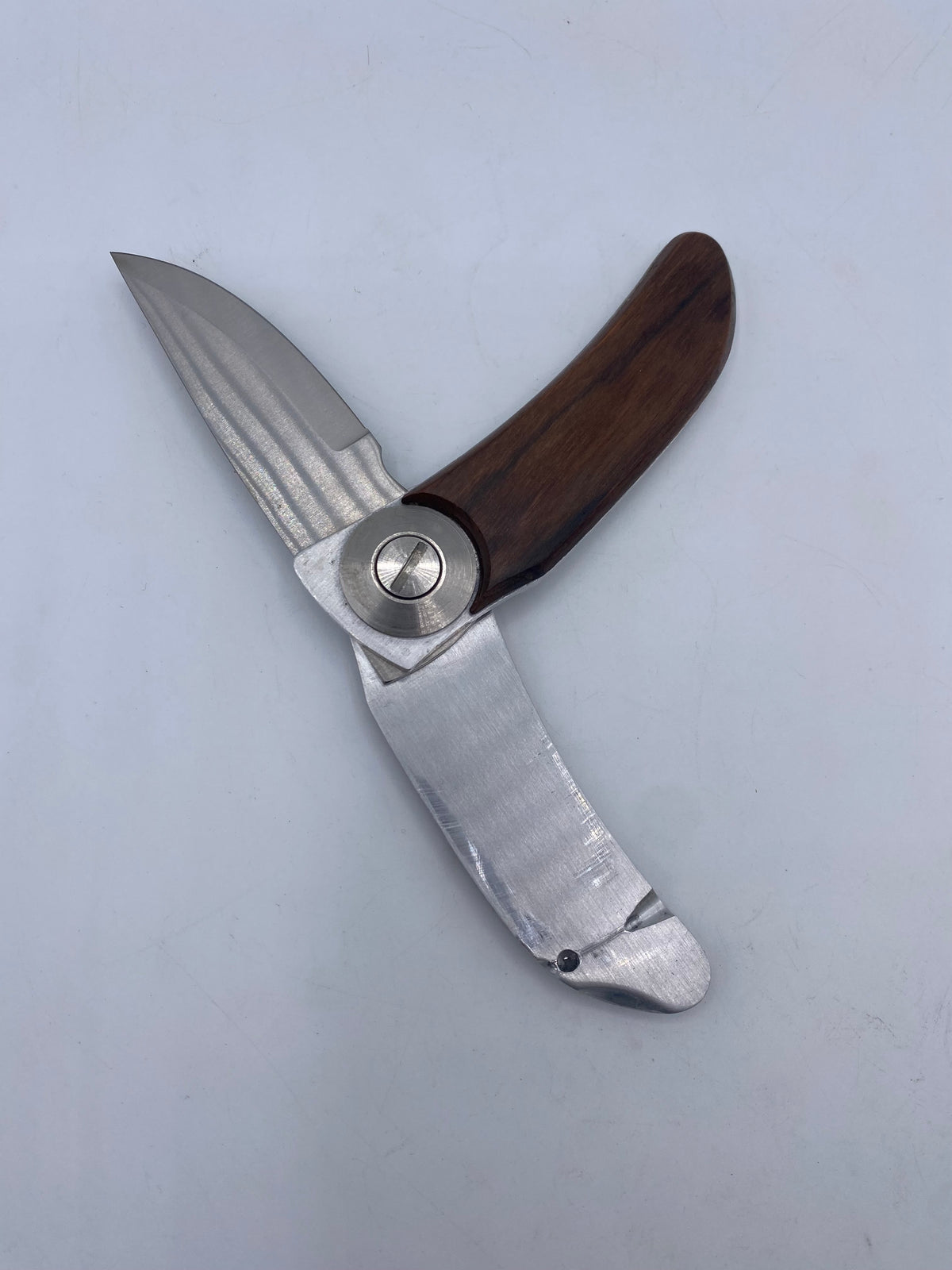 Folding knife after Barry Woods design in stainless steel and wood.