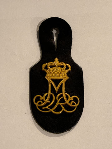 Margrethe d.2. Rex mærke, med knaphulsholder i læder.