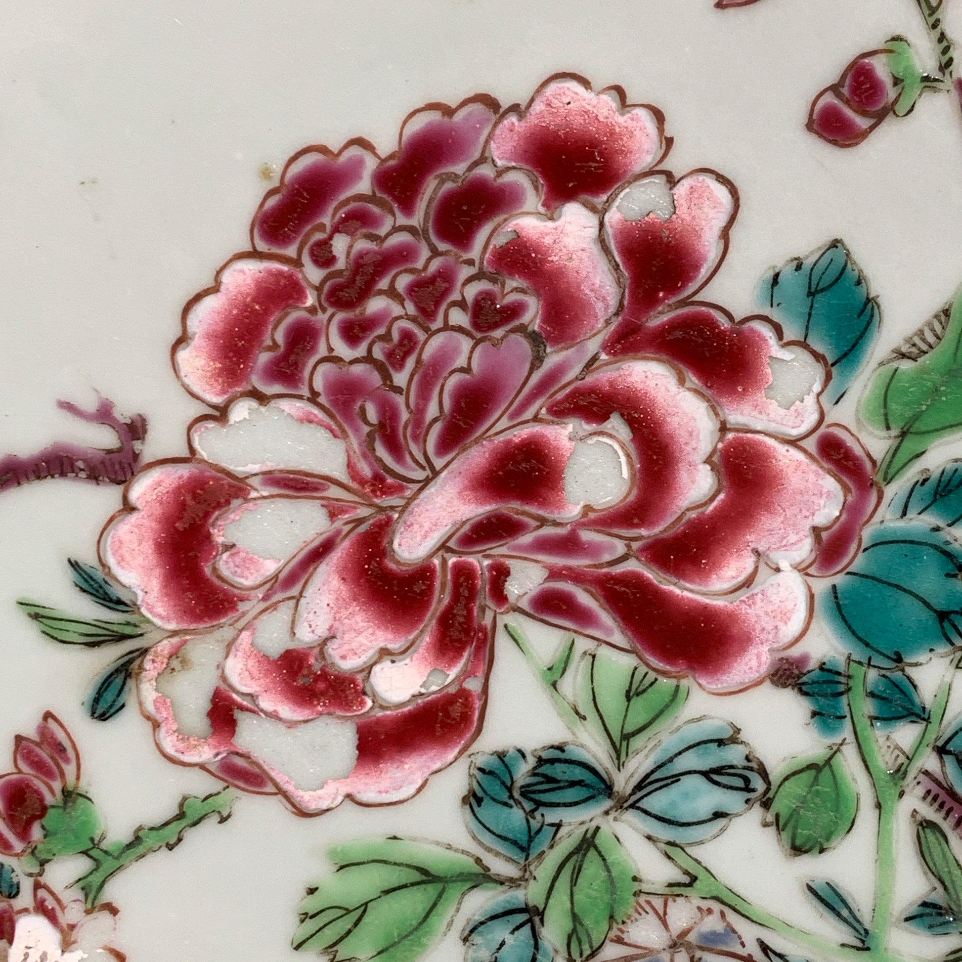 En kinesisk famille rose tallerken fra Qianlong Dynastiet (år 1735-1796) med en ros på et blåt og grønt mønster