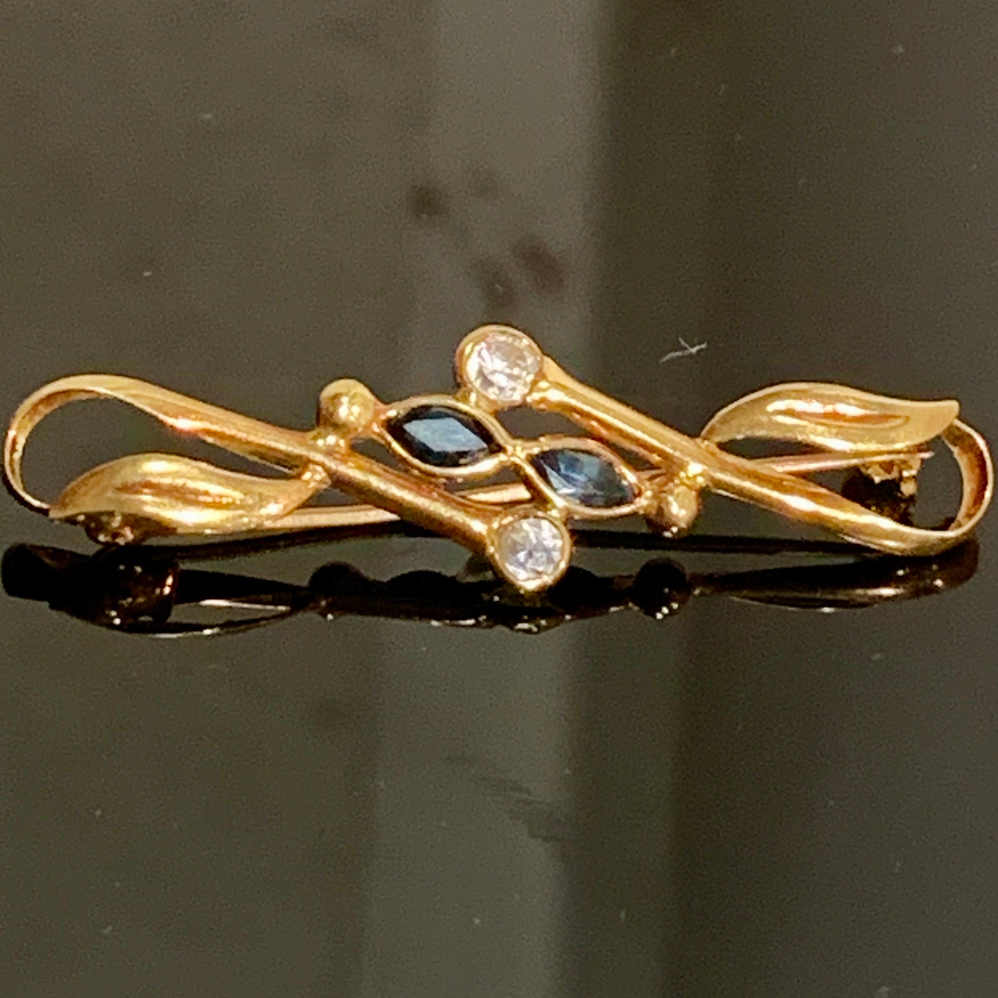 Et vintage 18 karats guld broche med safirer og zirconer, fra Italien