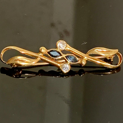 Et vintage 18 karats guld broche med safirer og zirconer, fra Italien