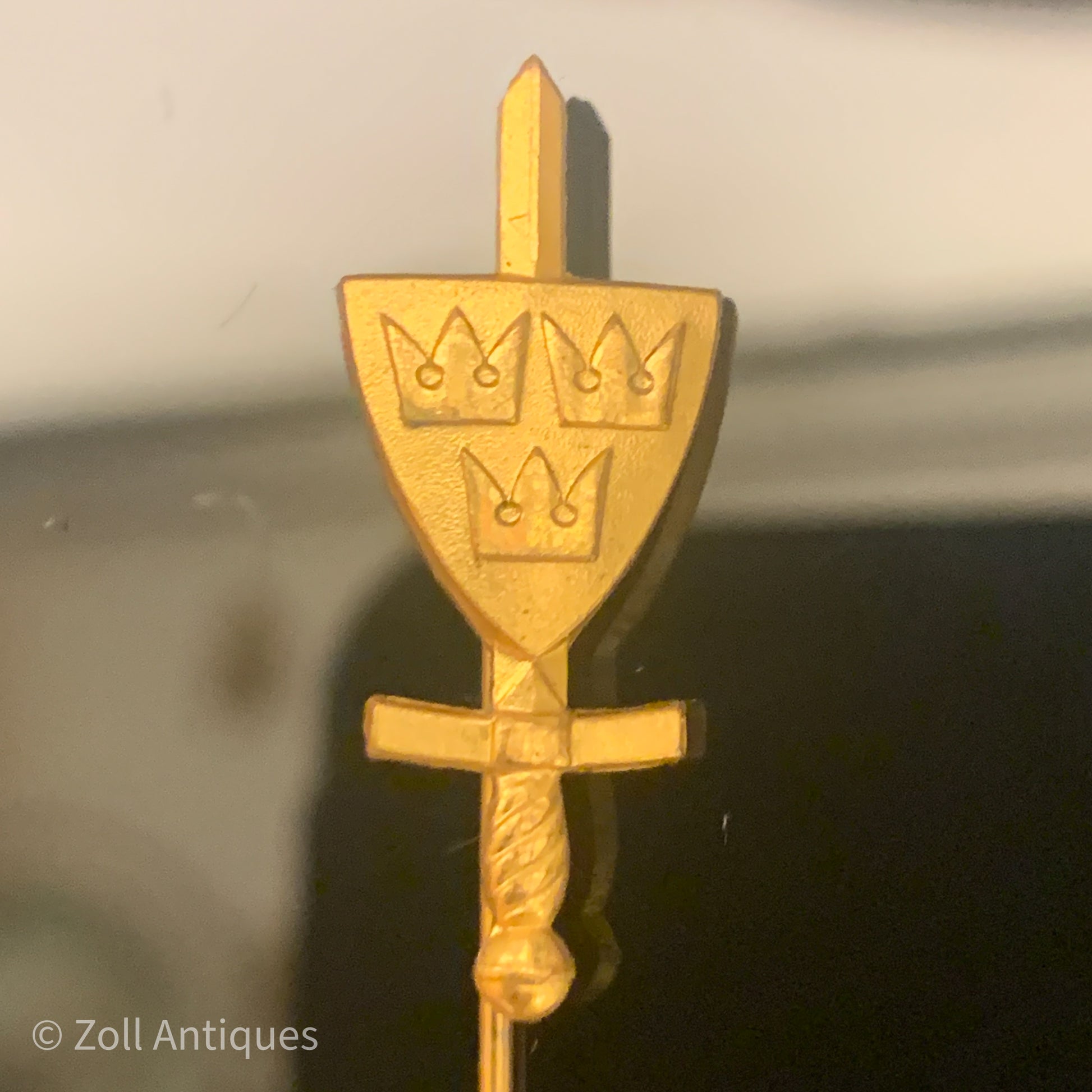 En gammel svensk militær nål med en sporrong og co. emblem