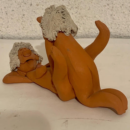Vintage stoneware caricature figurine of loving couple.